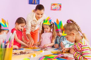 Teacher teaching preschool kids in art class