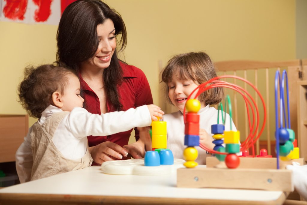 Female Early Education Teacher Working In Kindergarten